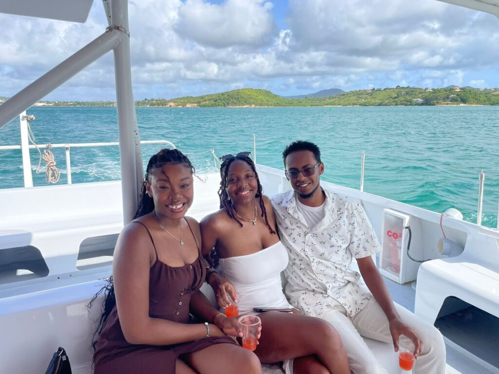 Sunset cruise aboard the Mystic catamaran in Antigua with passengers enjoying vibrant skies and calm Caribbean waters."