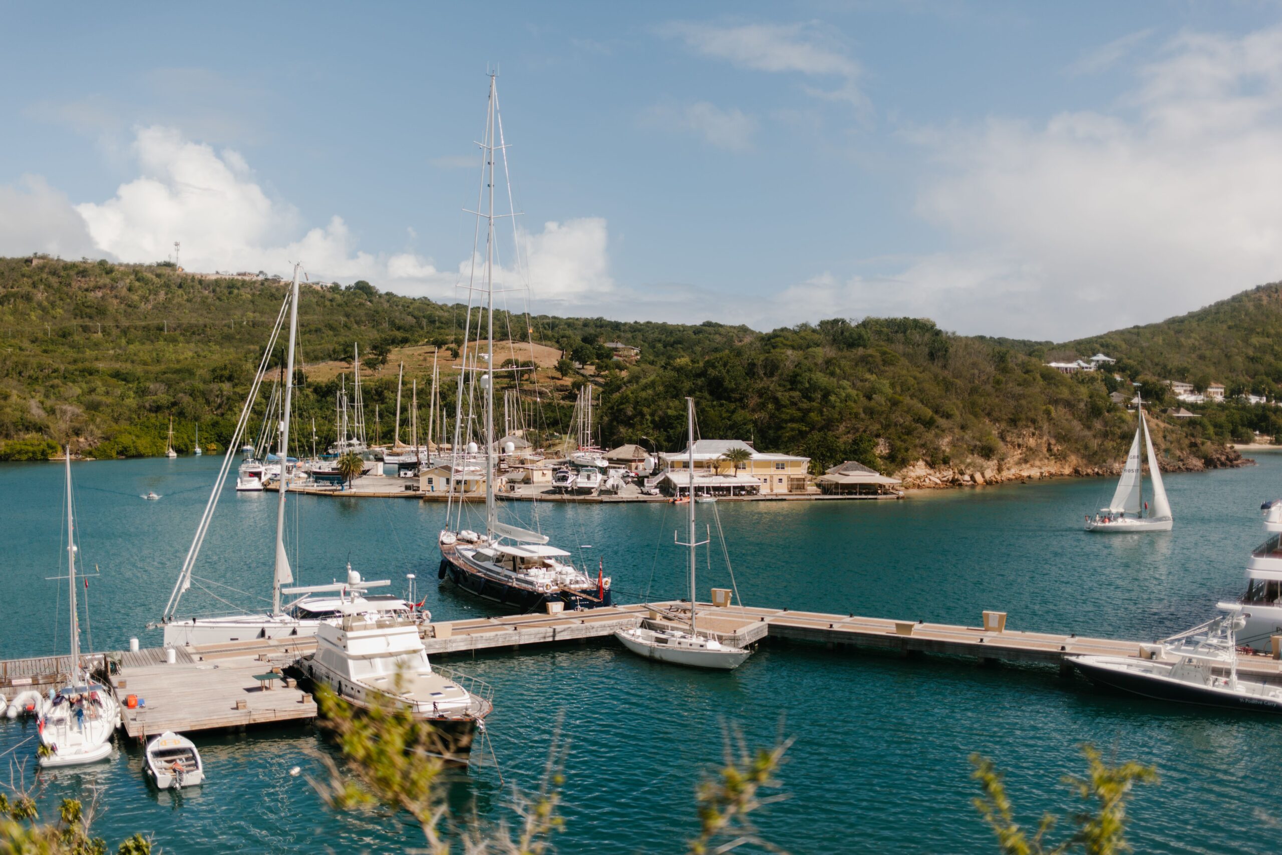 Aerial view of sailboats and yachts moored in English Harbour, Antigua, surrounded by lush green hills